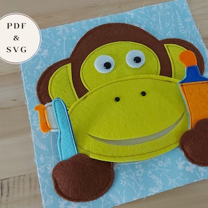Könnte beinhalten: Ein handgefertigter Affe aus Filz mit gelbem Gesicht, braunen Ohren und Kopf sowie einer blau-orangenen Zahnbürste. Der Affe befindet sich auf einem hellblauen Stoff mit floralem Muster. Der Text "PDF & SVG" befindet sich in einem Kreis oben links.