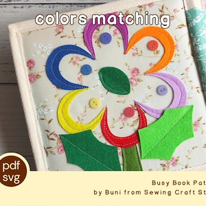 Può includere: Una pagina in tessuto di un libro attività con un fiore dai petali in feltro multicolore, foglie verdi e piccoli bottoni. Lo sfondo è una stampa floreale beige. Testo: colors matching, pdf svg, Busy Book Pattern by Buni from Sewing Craft Studio.