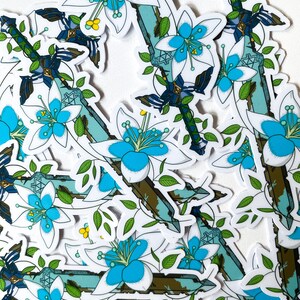 May include: A set of stickers featuring a stylized sword with blue and white flowers. The sword is depicted with a green and brown handle and a blue blade. The flowers are white with blue centers and green leaves.