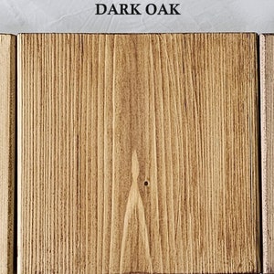 May include: Three wooden planks with different finishes are displayed. The first is labeled "ANTIQUE PINE" and has a light, warm tone. The second, "DARK OAK," is a rich brown. The third, "TUDOR OAK," has a darker, aged appearance.