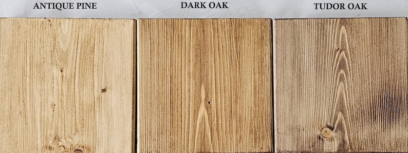 May include: Three wooden planks with different finishes are displayed. The first is labeled "ANTIQUE PINE" and has a light, warm tone. The second, "DARK OAK," is a rich brown. The third, "TUDOR OAK," has a darker, aged appearance.