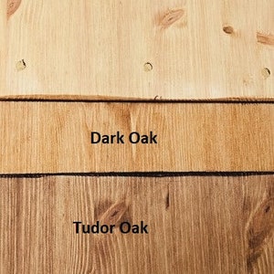 May include: Three wood samples showing different wood stains. The top sample is a light wood with the text "Antique Pine". The middle sample is a darker wood with the text "Dark Oak". The bottom sample is a medium brown wood with the text "Tudor Oak".