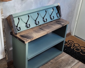 May include: A teal blue wooden shoe rack with two shelves and a coat rack with five black hooks. The rack is made of reclaimed wood and has a rustic finish.