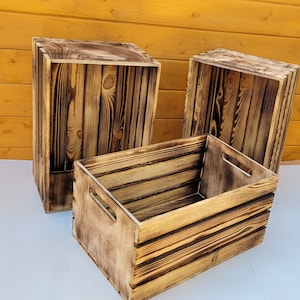 Puede incluir: Tres cajas de madera con un acabado r&uacute;stico quemado. Las cajas est&aacute;n apiladas una encima de la otra, con la caja m&aacute;s grande en la parte inferior y la caja m&aacute;s peque&ntilde;a en la parte superior. Las cajas est&aacute;n hechas de madera natural y tienen un aspecto desgastado.