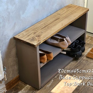 Op de afbeelding: Een houten schoenenbank met twee planken. De bovenkant is donker eiken gebeitst en de basis is cappuccino geverfd. De bank is 80 cm x 45 cm x 22 cm.