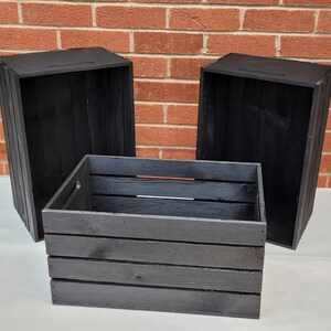 Puede incluir: Tres cajas de madera negras, dos est&aacute;n abiertas y una est&aacute; cerrada. Las cajas son de madera con un acabado r&uacute;stico.