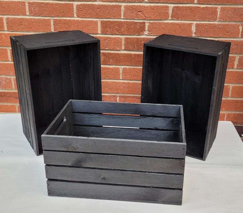 Puede incluir: Tres cajas de madera negras, dos est&aacute;n abiertas y una est&aacute; cerrada. Las cajas son de madera con un acabado r&uacute;stico.