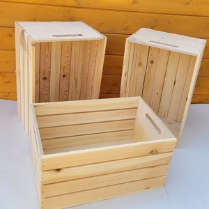 Puede incluir: Tres cajas de madera, dos est&aacute;n apiladas una encima de la otra, la tercera est&aacute; delante de la pila. Las cajas son de madera natural con un acabado marr&oacute;n claro. Las cajas tienen un dise&ntilde;o sencillo con una forma rectangular y un asa en la parte superior.