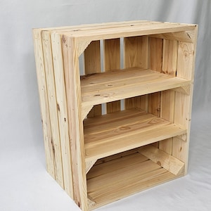 May include: A wooden shelf unit made from natural wood with three shelves. The shelf unit is made from stacked wooden crates.