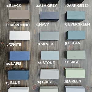 May include: A wooden color palette featuring 18 painted blocks in various shades. Colors include black, ash grey, dark green, cappuccino, navy, evergreen, white, silver, ocean, lapis, stone, sage, blue, grey, green, sky, olive, and dove grey.