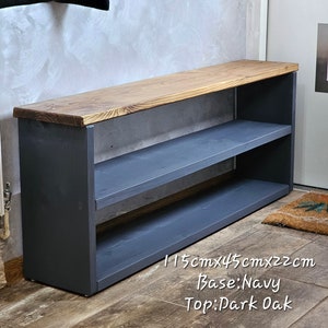 Op de afbeelding: Een schoenenrek met een bovenblad van donker eikenhout en een donkerblauwe basis. Het rek heeft twee planken en meet 115 cm x 45 cm x 22 cm.