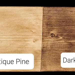 May include: A sample of four wood finishes: Clear Wax, Antique Pine, Dark Oak, and Tudor Oak. Each finish is displayed on a rectangular wooden plank, showcasing the color variations from light to dark. The names of the finishes are displayed in white text.