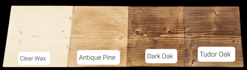 May include: A sample of four wood finishes: Clear Wax, Antique Pine, Dark Oak, and Tudor Oak. Each finish is displayed on a rectangular wooden plank, showcasing the color variations from light to dark. The names of the finishes are displayed in white text.