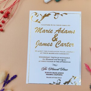 Invitación de boda de lujo con lámina dorada, escritura en relieve y borde en espiral para una ceremonia formal elegante.