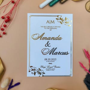 Invitación de boda clásica en relieve dorado con esquinas florales ornamentadas y un borde elegante para un anuncio de boda lujoso y atemporal.