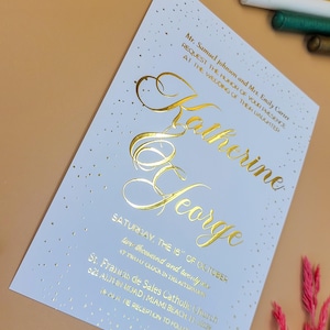 Invitación de boda clásica en relieve dorado con elegante escritura y patrón de puntos: diseño formal en relieve para ceremonias tradicionales.