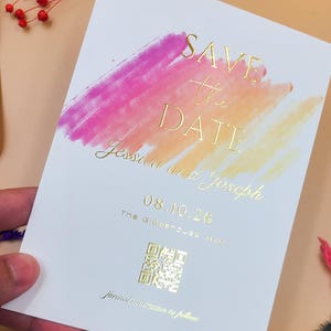 Tarjeta de invitación para boda con pinceladas de atardecer moderno y lámina dorada en relieve: anuncio de boda en acuarela brillante con código QR y acabado de lujo.