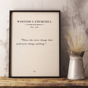 Op de afbeelding: Zwart-witte geprinte afbeelding in een lijst met een citaat van Winston S. Churchill: "Degenen die nooit van gedachten veranderen, veranderen ook niets." Het citaat is gecentreerd op een beige achtergrond met de naam van de auteur en de data (1874-1965) erboven.