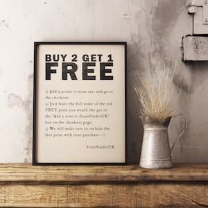 May include: A black and white printable sign with the text "BUY 2 GET 1 FREE" and instructions on how to redeem the offer. The sign is framed and sitting on a wooden surface with a small metal pitcher and dried flowers.
