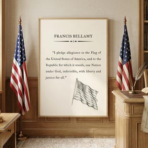Può includere: Due bandiere americane fiancheggiano una stampa incorniciata del Giuramento di fedeltà. La stampa presenta il testo "FRANCIS BELLAMY" e il giuramento stesso. La stanza ha un tema patriottico classico con una scrivania e una libreria.