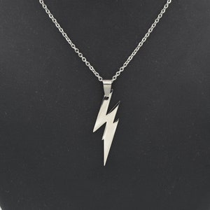 May include: A silver chain necklace with a lightning bolt pendant.