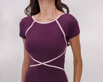 May include: Plum-colored short-sleeved jumpsuit with light pink trim. The jumpsuit features a scoop neckline and crisscross design on the bodice. The fabric appears to be a soft knit material, suitable for athletic wear or casual outfits.