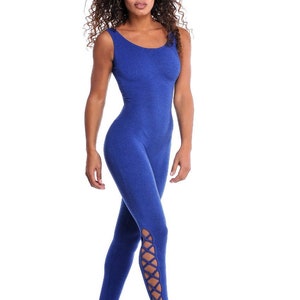 May include: A blue jumpsuit with a scoop neckline and stirrup bottoms. The jumpsuit has crisscross detailing on the lower legs. The model is standing against a white background.