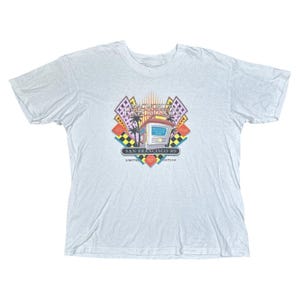May include: A light blue t-shirt featuring a graphic of a building with the text "MacWorld Exposition San Francisco '89 Limited Edition".