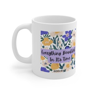 May include: White ceramic mug with a floral design featuring yellow, white, and purple flowers. The mug has the text "Everything Beautiful In It's Time ECC 3:11" printed on it.
