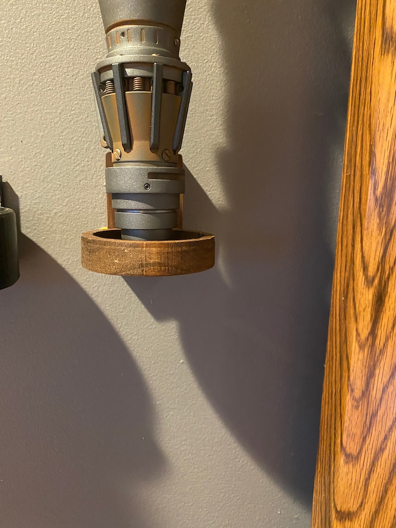 Pu&ograve; includere: Un modello di motore a razzo in metallo argentato e dorato montato su una base in legno. Il motore a razzo presenta un design dettagliato con pi&ugrave; parti e una superficie testurizzata.