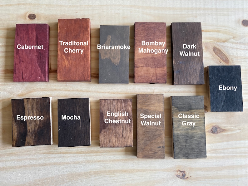 May include: A wood stain color chart with 14 different wood stain colors. The colors are labeled with names like Cabernet, Traditional Cherry, Briarsmoke, Bombay Mahogany, Dark Walnut, Espresso, Mocha, English Chestnut, Special Walnut, Classic Gray, and Ebony.