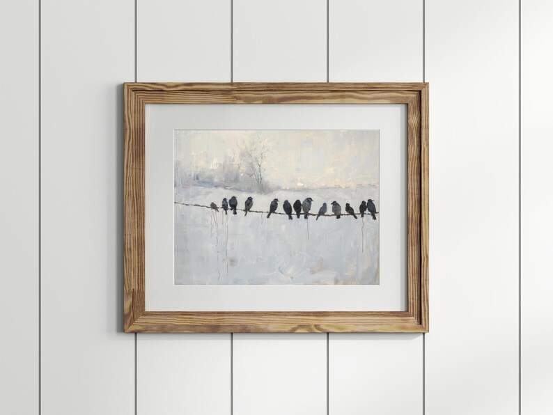 May include: A framed art print featuring a painting of several dark birds perched on a wire against a light, textured background. The artwork is in a wooden frame, creating a rustic aesthetic. The birds are silhouetted.