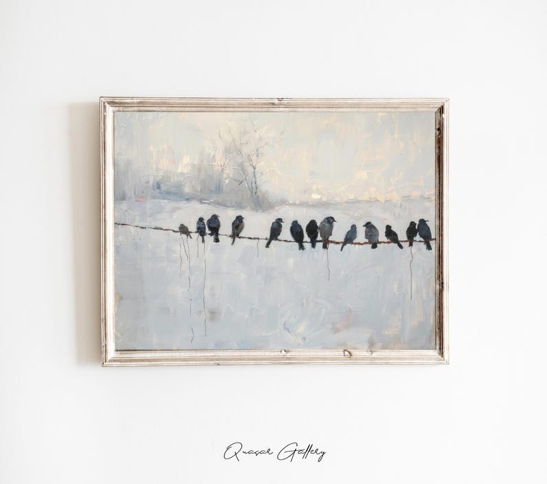 May include: A framed painting depicts a winter scene with a row of black birds perched on a wire against a pale blue and white background. The artwork has a vintage aesthetic, with a silver-colored frame and a soft, painterly style.