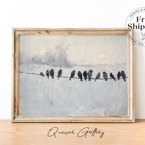 May include: A framed painting depicts a row of birds perched on a wire against a muted, snowy landscape. The artwork features a neutral color palette with a distressed, light-colored wooden frame. The painting is signed "Quasar Gallery".