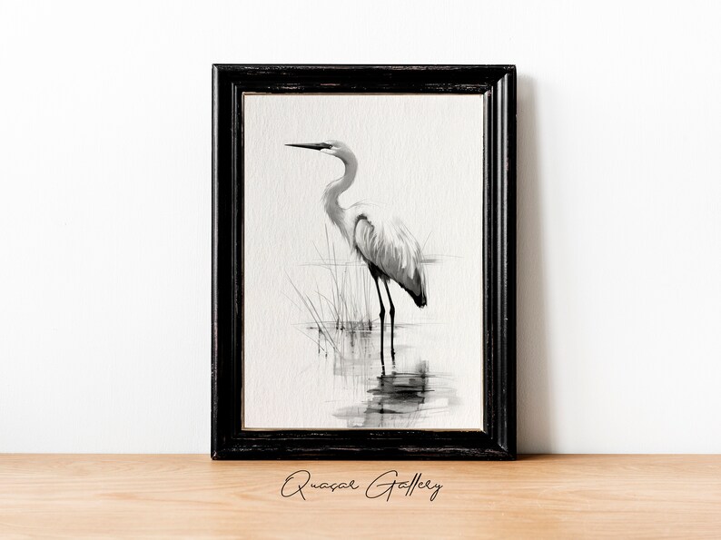May include: Black and white watercolor painting of a great egret standing in a marsh. The bird is facing to the left and its reflection is visible in the water.
