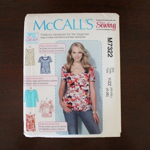 May include: McCall's Sewing pattern M7322 for sizes XS-XXL (4-26). The pattern includes instructions for sewing a top with a square neckline. The model is wearing a red and white floral top with blue jeans.