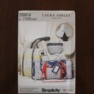 May include: A sewing pattern for a tote bag, a small bag, and a hat. The pattern is from Laura Ashley and is Simplicity pattern number S9814. The pattern is for all sizes.