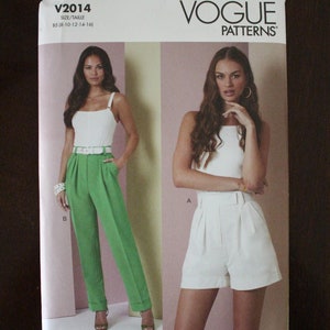 May include: Vogue Patterns sewing pattern for a pair of high-waisted shorts and pants. The pattern is for sizes 8-10-12-14-16. The pattern shows two models wearing the garments. One model is wearing white shorts and the other is wearing green pants.