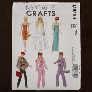 May include: A McCall's Crafts sewing pattern, M6258, featuring illustrations of various outfits. The cover displays a bride in a wedding dress, a woman in a teal gown, and other fashion designs. The pattern size is OSZ.
