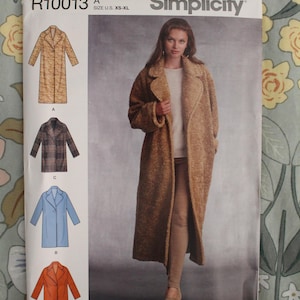 May include: A Simplicity sewing pattern envelope R10013 for a coat in sizes XS-XL. The front shows a long, textured brown coat, with illustrations of four variations labeled A, B, C, and D, including plaid, blue, and orange options.