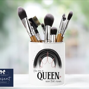 May include: White ceramic makeup brush holder with a black and white rainbow design and the text "You are a QUEEN wear that crown".