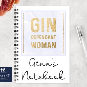 May include: A white spiral bound notebook with a gold glitter design and the text "GIN DEPENDANT WOMAN Gina's Notebook".
