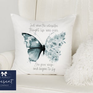 May include: White cushion with a blue watercolour butterfly and the text "Just when the caterpillar thought life was over She grew wings and began to fly".