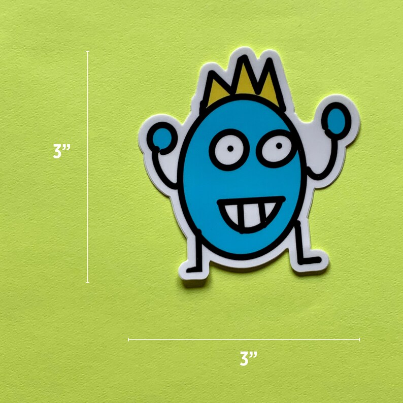 May include: A 3-inch by 3-inch sticker featuring a blue cartoon character with a yellow crown, white eyes, and a toothy grin. The character is wearing a blue crown and has two small blue circles on its arms.