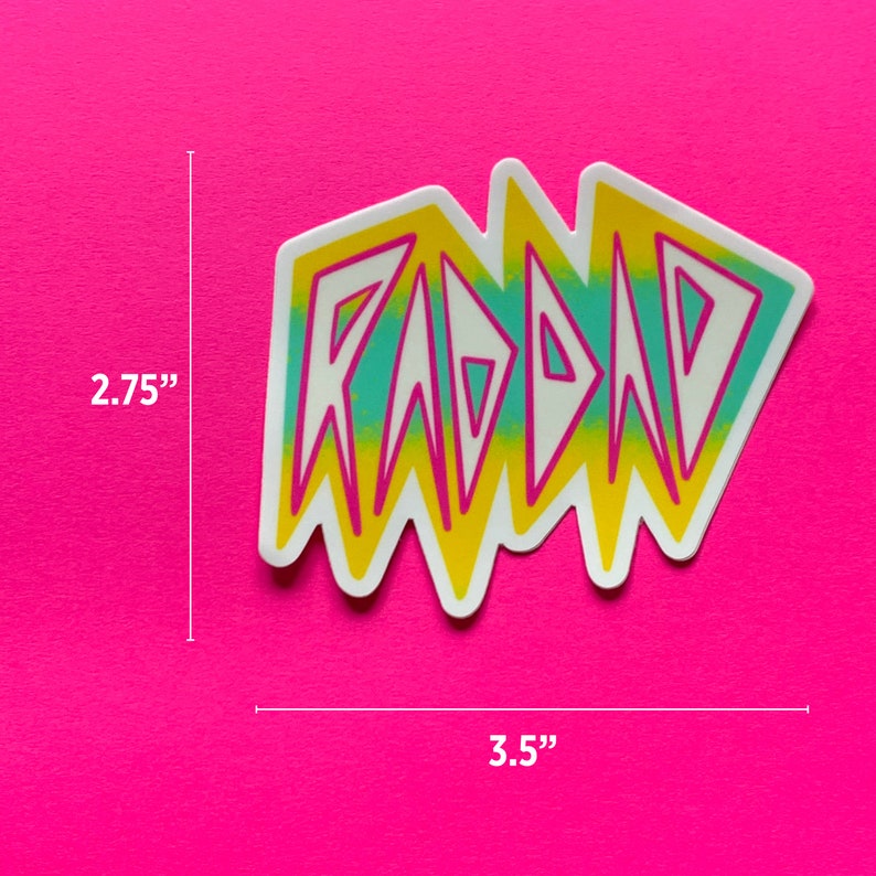 May include: A white sticker with the word "RAD" in yellow, pink, and blue letters. The sticker is 3.5 inches wide and 2.75 inches tall.