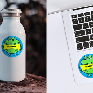 May include: A white water bottle with a green frog sticker on it. The sticker says "TOADALLY."