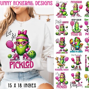May include: White sweatshirt with a large graphic of a pickle character playing pickleball, the word "PICKLED" in pink, and the text "15 FUNNY PICKLEBALL DESIGNS". The design is 15 x 18 inches.
