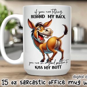Może przedstawiać: Biały ceramiczny kubek o pojemności około 425 ml z ilustracją osła z kreskówki. Osioł jest brązowy i brązowy, z szerokim uśmiechem i tekstem "Jeśli mówisz za moimi plecami, jesteś w dobrej pozycji, żeby pocałować moją dupę."