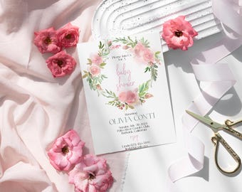 May include: A white baby shower invitation with a watercolor wreath of pink flowers and green leaves. The text reads "Please join us for a baby shower" and "Honoring Olivia Conti".