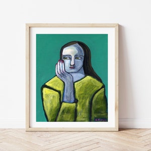 May include: Framed art print featuring a stylized portrait of a person with blue skin, green eyes, and long dark hair. The person is wearing a yellow-green top and resting their chin on their hand. The background is teal.